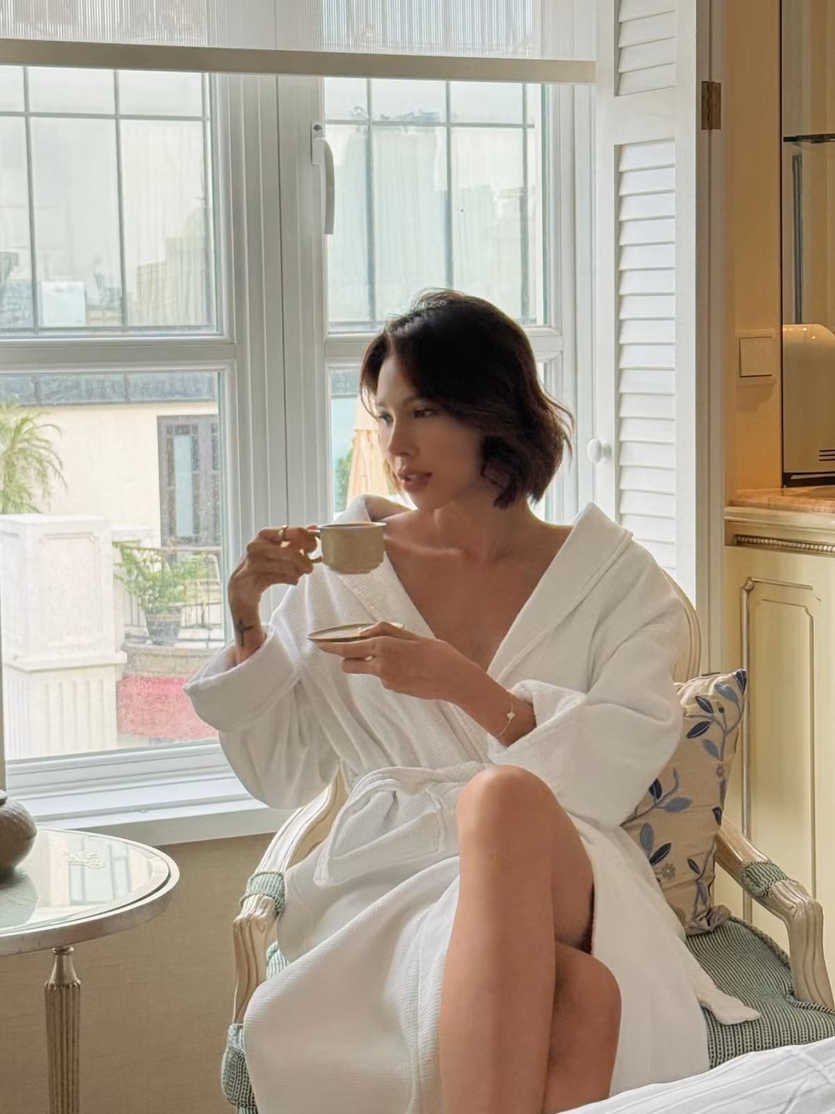 Minh Triệu diện đồ ngủ gợi cảm, tạo dáng với tách trà. Ảnh: FB Pham Dinh Minh Trieu