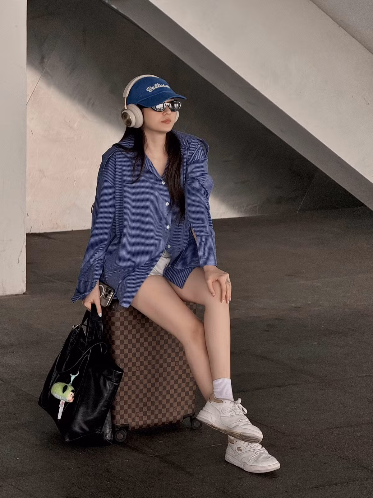 Bảo Anh diện áo sơ mi rộng theo style giấu quần check-in ở sân bay khi ra Bắc công tác.