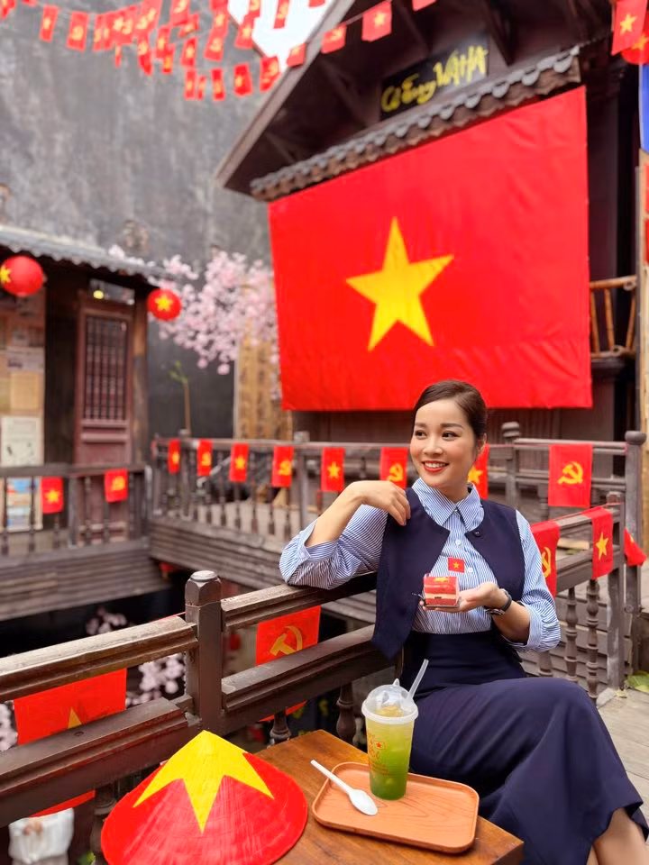 MC Minh Hương chụp ảnh với cờ đỏ sao vàng. Ảnh: FB Le Minh Huong