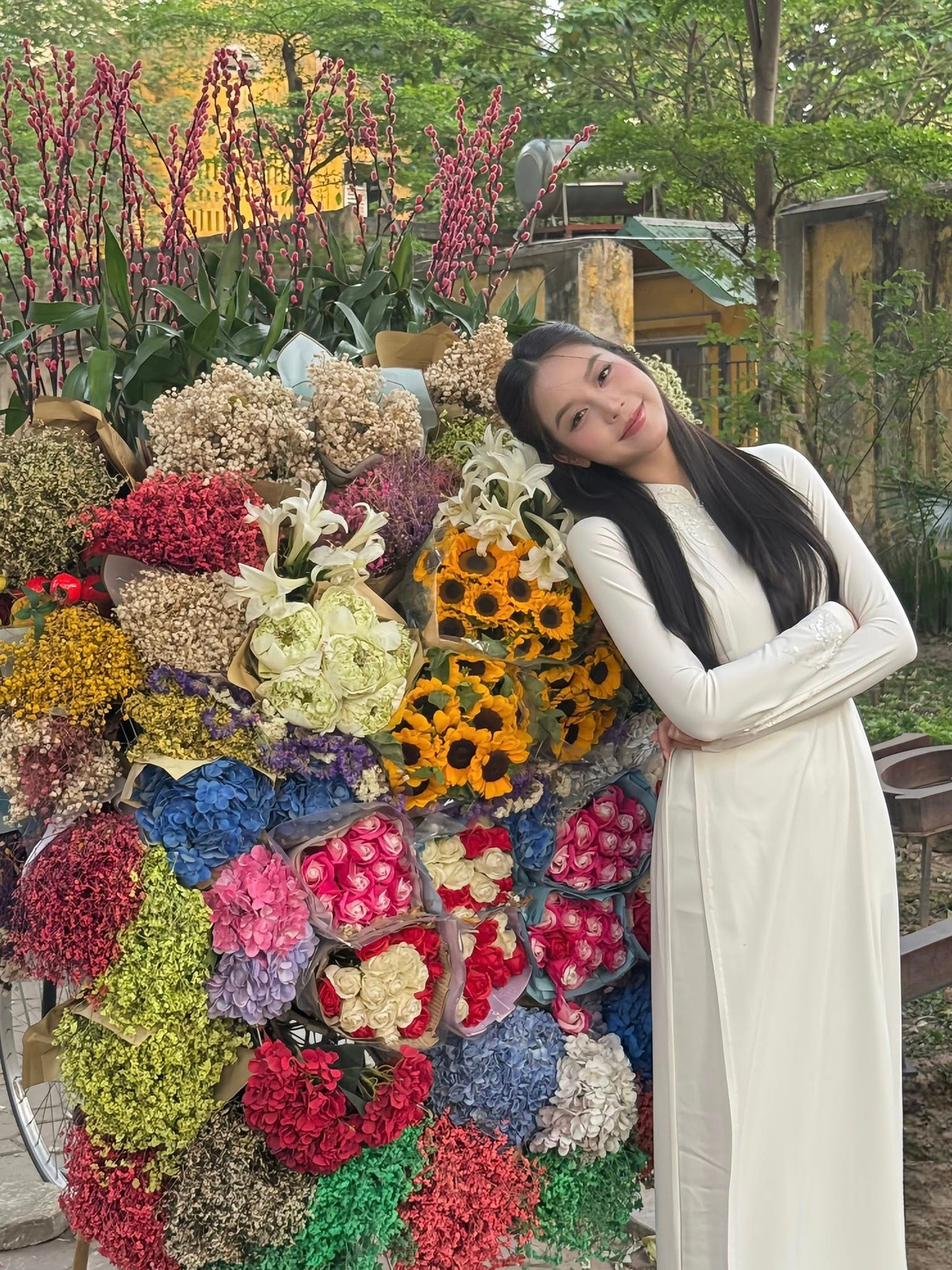 Hoa hậu Thanh Thuỷ mặc áo dài trắng chụp bên xe hoa. Ảnh: FB Huỳnh Thị Thanh Thủy