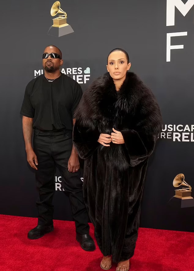 Bên ngoài chiếc váy lưới, Bianca mặc một chiếc áo khoác lông dài màu đen. (Ảnh: WireImage)