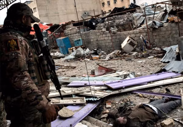 Thi thể một chiến binh khủng bố bị bắn hạ nằm giữa đống đổ nát.