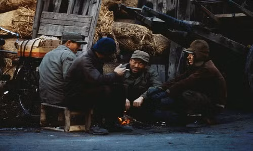 Những người đàn ông ngồi quanh đống lửa sưởi ấm trong ngày đông lạnh giá. Ảnh: VT.