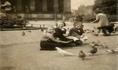 Những em bé gái ngồi cho chim bồ câu ăn ở Berlin hồi thập niên 1930. Ảnh: VT.