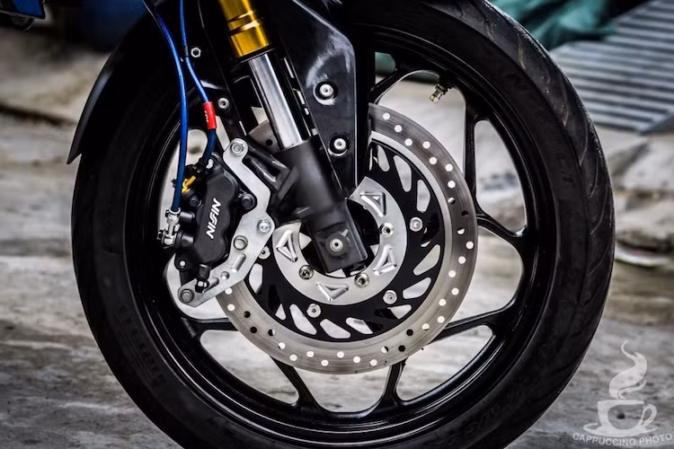 Để đảm bảo an toàn, hệ thống phanh trước của xe đã được nâng cấp bằng heo Nissin 3 piston của Honda SH300i, kèm theo đĩa Honda CBR150R. Cặp mâm nguyên bản của xe cũng đã được thay bằng mâm Asio bản lớn 5 cánh kép, kèm theo lốp Pirelli bám đường hơn.