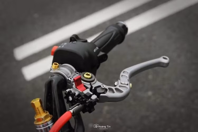 Ngoài những con ốc titan Proti nổi bật, chiếc xe đã được chủ nhân trang bị cặp bao tay từ Honda SH Mode ở cả hai bên tay nắm. Trong khi đó, cùm côn của xe được thay bằng cùm CRG đẹp mắt.