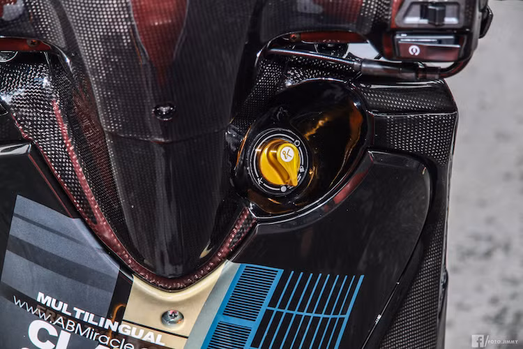 Một điểm đặc biệt của chiếc SH 2010 độ này đó là những chi tiết bằng nhựa đen nguyên bản của chiếc xe đã được chủ nhân đặt hoàn thiện với bề mặt sợi carbon thật, đem tới cho xe vẻ đẹp như những siêu môtô hàng đầu Thế giới với vỏ carbon. Hệ thống khóa của xe cũng đã được độ lên khóa thông minh Smart Key với núm vặn khởi động bằng nhôm CNC đẹp mắt.