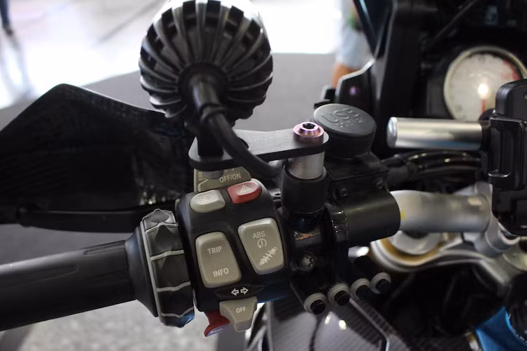 Các công tắc điều khiển đèn của xe được giấu gọn bên dưới cùm công tắc zin bên trái của xe, ngay phía trên là cổng sạc USB cho các thiết bị cá nhân. Các hệ thống điện tử nguyên bản của S1000XR như ABS, hệ thống treo, giữ ga tự động... vẫn được điều khiển thông qua cùm công tắc trái.