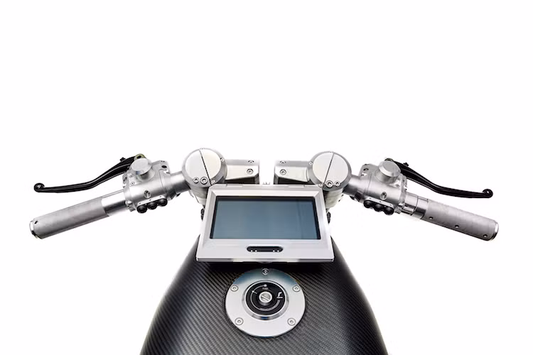 Cũng giống như phuộc trước, các cùm phanh và côn của Vanguard cũng được giấu hoàn toàn trong lớp vỏ nhôm CNC, kiêm chỗ gắn các công tắc của xe. Nằm phía trên bình xăng với vỏ ngoài bằng sợi carbon là nắp xăng của Rizoma cùng với một màn hình lớn đóng vai trò là bảng đồng hồ trên xe.