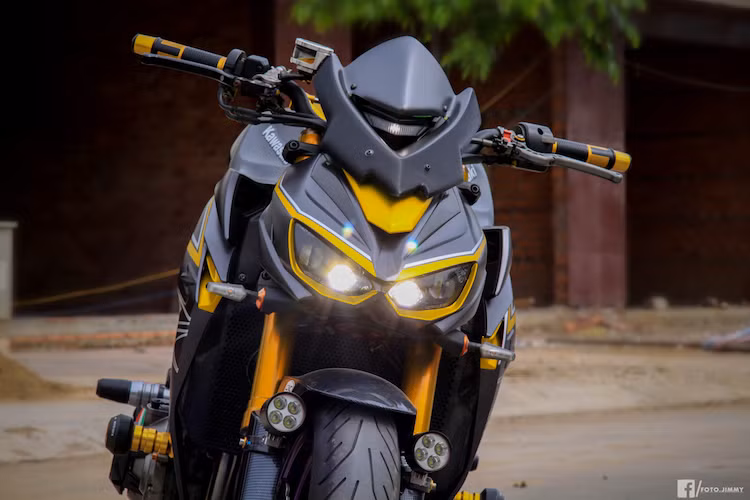 Để chiếc xe có ngoại hình giống như Z1000R, Gần như toàn bộ thân xe đã được chủ nhân đặt dán kết hợp giữa 2 tông màu xám phay xước kim loại và vàng candy. Cặp xi-nhan trước đã được thay bằng loại Rizoma Action. Dè trước của xe được dán carbon, nằm hai bên là cặp đèn LED L4 trợ sáng trong đêm.