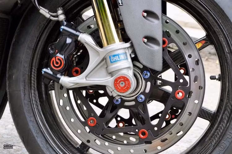 Vốn đã có phuộc Ohlins NIX30 "hàng hiệu" ở phía trước, chiếc xe còn tiếp tục được nâng cấp "dàn chân" với mâm BST 7 cây bằng sợi carbon, cùng với hệ thống phanh mới sử dụng heo Brembo Billet. Chụp cốt CNC Racing và những chiếc ốc titan tạo thêm điểm nhấn ở bánh trước xe.