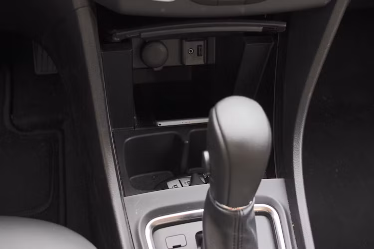 Các cổng USB và jack cắm tai nghe của Ciaz được bố trí ở hộc đựng đồ phía dưới xe, ngay cạnh là một ổ điện 12V có nắp che. Hộc đựng đồ này được tích hợp luôn khay để cốc và khá rộng rãi, "dư chỗ" đựng một số đồ dùng cá nhân như điện thoại hay ví. Xe còn có sẵn cửa kính điều khiển trung tâm với tính năng đóng mở tự động và chống kẹt, nút khởi động start/stop và khóa thông minh.