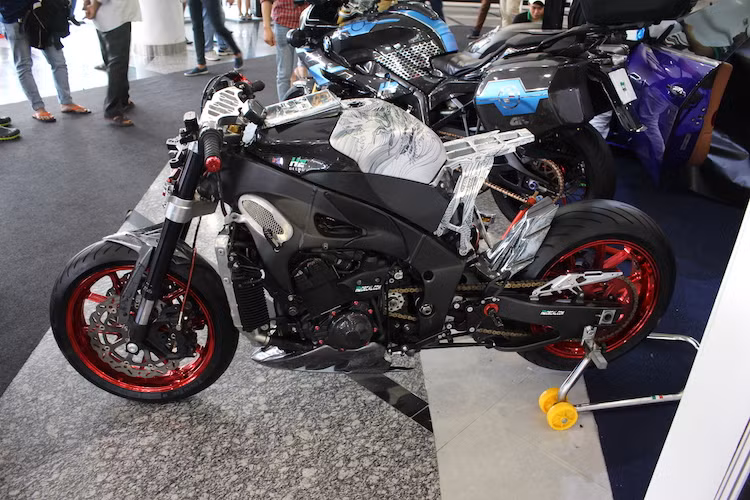 Trên bản độ này, toàn bộ dàn vỏ nguyên bản cùng khung phụ phía sau của chiếc R1 đã được "lột bỏ" hoàn toàn, khiến chiếc xe lộ ra vẻ đẹp cơ khí từ các chi tiết máy móc cực "cool". Ở vị trí hốc hút gió nguyên bản của xe nay là tấm lưới chắn với vỏ bằng sợi carbon.