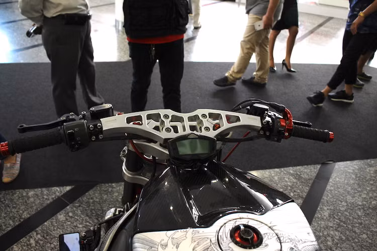 Thay vì tay lái clip-on nguyên bản, chiếc R1 đã được chủ xe kỳ công tiện riêng một ghi-đông bằng nhôm CNC "hàng thửa" rộng hơn, tạo tư thế ngồi của một chiếc streetfighter. Trên ghi-đông, đồng hồ Koso DB3 cung cấp các thông tin khi xe vận hành, trong khi cùm ga nguyên bản được thay bằng cùm ISR CNC nguyên khối.