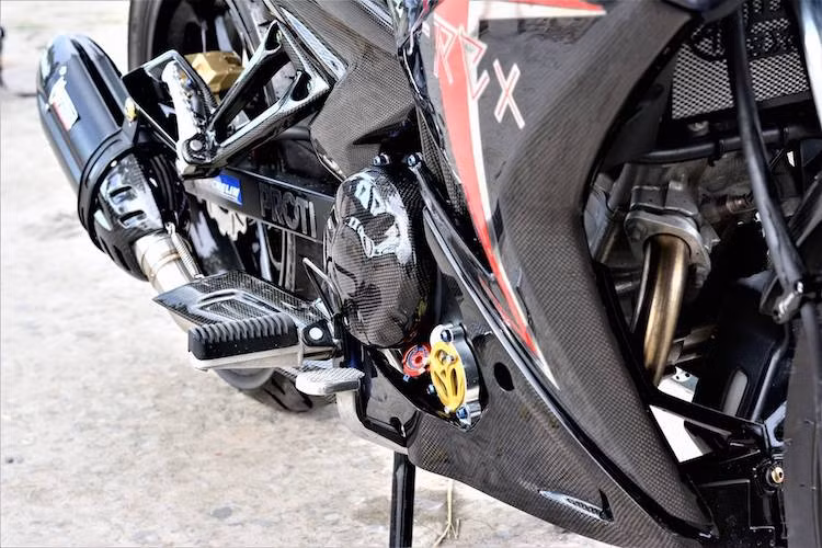 Ngoài ra ở bên bưởng côn, một số món đồ chơi trang trí nhỏ như nắp che lọc nhớt Racing Boy và nắp nhớt Rizoma cũng tạo điểm nhấn nổi bật bên cạnh những chi tiết dán sợi carbon của xe.