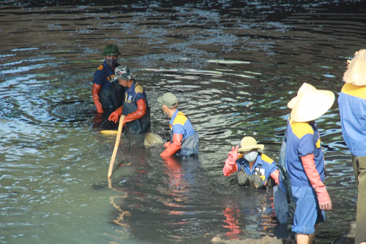 Giữa thời tiết nắng nóng, các công nhân đắm mình xuống lòng sông Tô Lịch đen xì khiến nhiều người dân qua đường cảm phục.