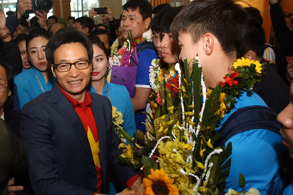 Trước đó, ngay khi đội tuyển U23 Việt Nam hạ cánh xuống sân bay Nội Bài, Phó Thủ tướng Vũ Đức Đam đã trao hoa chúc mừng cho từng cầu thủ trong đội bóng. Ảnh: VPG.