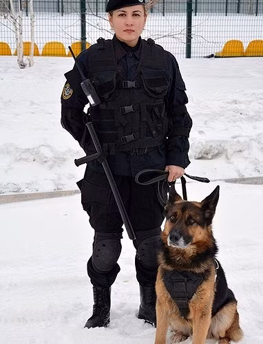 Một nữ quân nhân xinh đẹp khác của Kazakhstan, xuất hiện trên nền tuyết với một chú chó béc-giê nghiệp vụ.