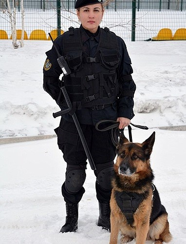 Một nữ quân nhân xinh đẹp khác của Kazakhstan, xuất hiện trên nền tuyết với một chú chó béc-giê nghiệp vụ.
