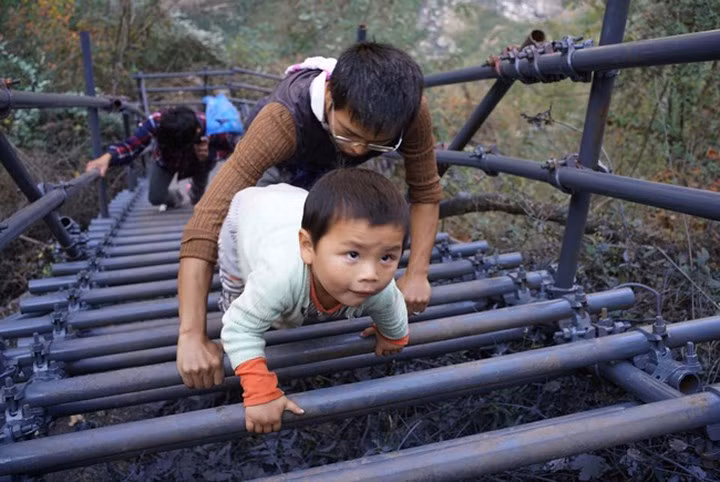 Học sinh ở đây (từ 3 - 4 tuổi) khi tới trường phải leo thang gỗ. Vì bị chỉ trích mạnh nên bây giờ chính quyền đã đầu tư bài bản hơn.