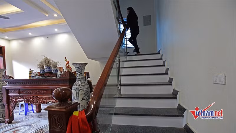 Tay vịn cầu thang được làm bằng gỗ và vách kính trong suốt tôn lên sự sang trọng của căn nhà.