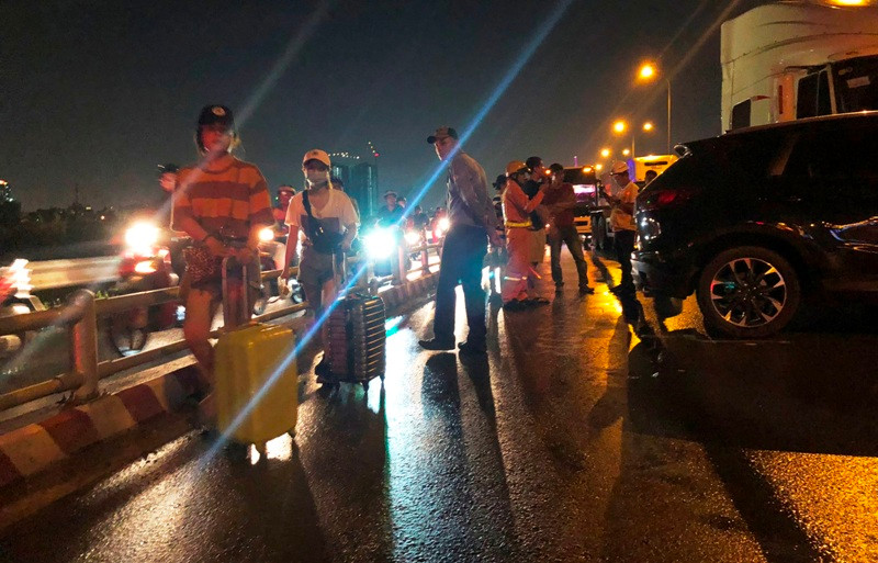 Nhiều người dân do trễ công việc phải xuống xe, kéo hành lý đi bộ trên cao tốc để thoát khỏi kẹt xe.