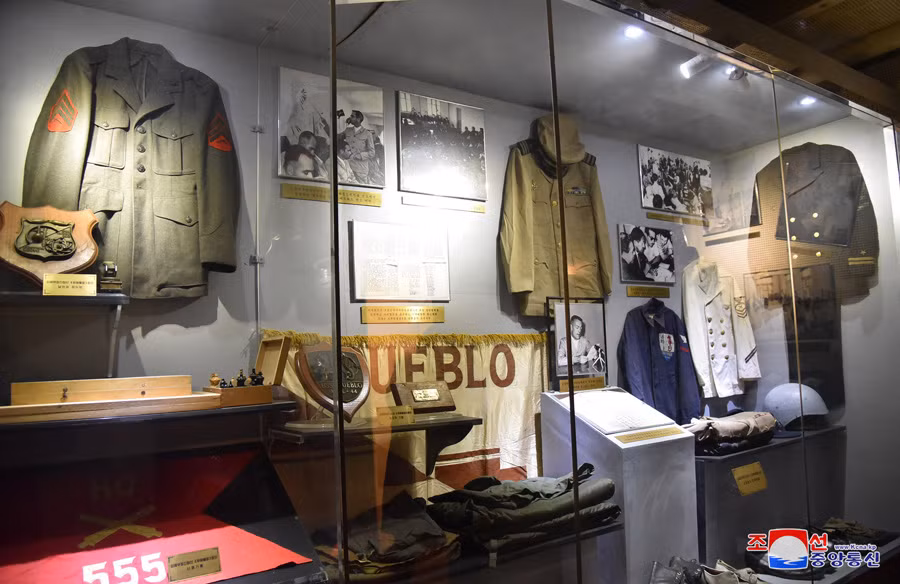 Bên trong con tàu trưng bày nhiều hiện vật, trong ảnh là cờ của tàu USS Pubelo cùng quân phục và quân trang của thủy thủ trên tàu. (Ảnh: KCNA)