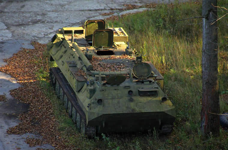 Một chiếc xe bọc thép chở quân rỉ sét trong căn cứ.