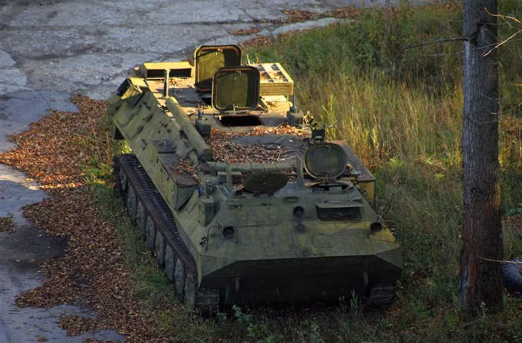 Một chiếc xe bọc thép chở quân rỉ sét trong căn cứ.