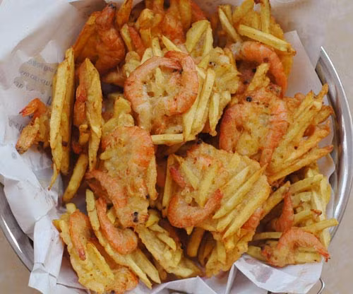 Bánh tôm khoai lang chiên: Bằng cách trộn khoai lang thái sợi, bột mì, nước và tôm to thành hỗn hợp sền sệt rồi đem chiên vàng, bạn đã có món bánh tôm khoai lang. Món này ăn kèm nước chấm chua ngọt và các loại rau sống