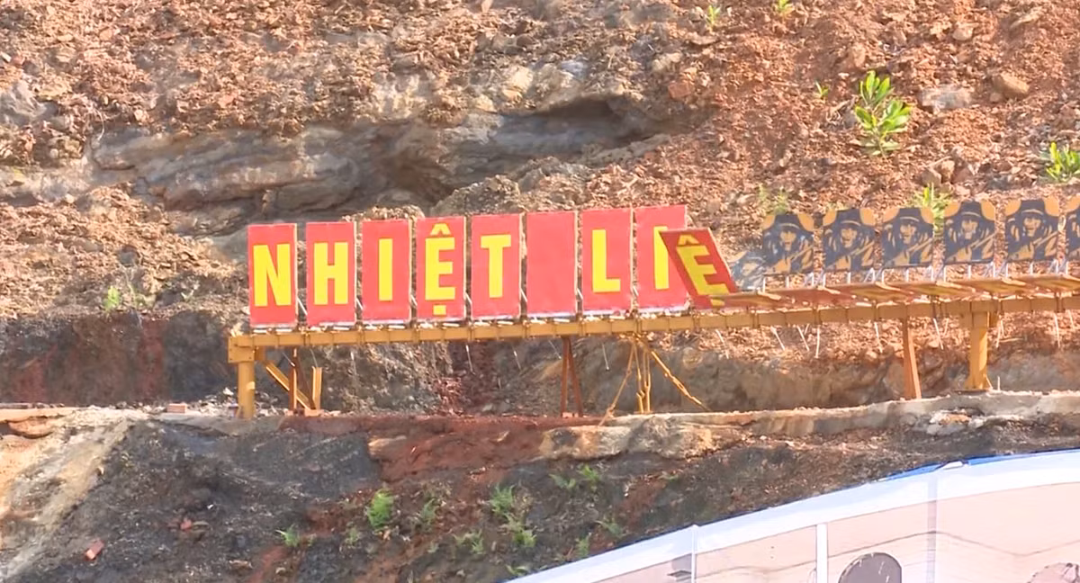 Đạn chạm vào bia, lập tức mặt bia bị hất ra sau và kéo biển gắn các chữ cái xếp thành khẩu hiệu nền đỏ chữ vàng bật lên.