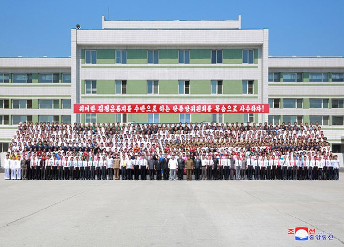 Ông Kim Jong Un chụp ảnh lưu niệm cùng cán bộ công nhân viên của nhà máy.