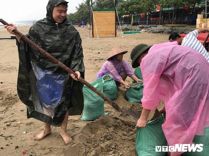 Người dân khẩn trương lấy cát để chặn mái tôn, tường rào, bảo vệ nhà cửa, hàng quán trước bão số 3.
