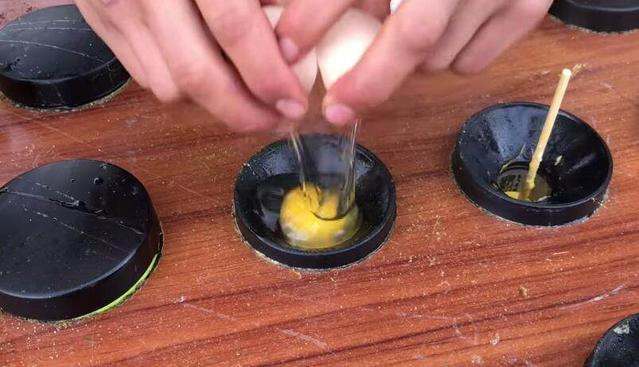 Sau khi phết dầu vào lỗ trũng, người ta sẽ đập trứng vào lỗ