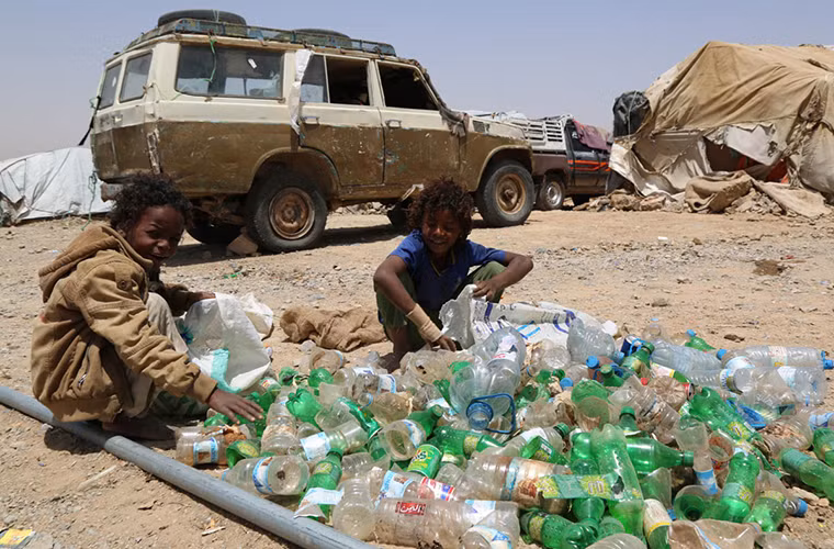 Bé Obaid (9 tuổi) cùng bạn, Modrek, phải đi nhặt rác kiếm sống qua ngày. Ảnh: AJ.