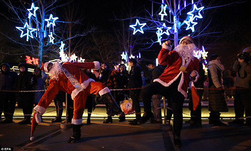 Hai “ông già Noel” tạo dáng chụp ảnh bên ngoài Nhà thờ Xuanwumen ở thủ đô Bắc Kinh, Trung Quốc, trong đêm Giáng sinh. Ảnh: EPA.
