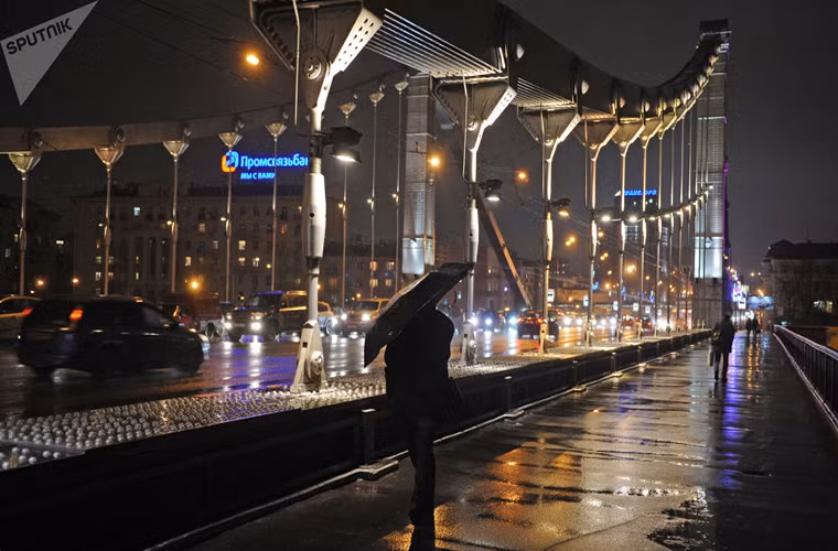Người đi bộ che ô dưới trời mưa trên cầu Crimean ở Moscow năm 2011. Ảnh: Sputnik.