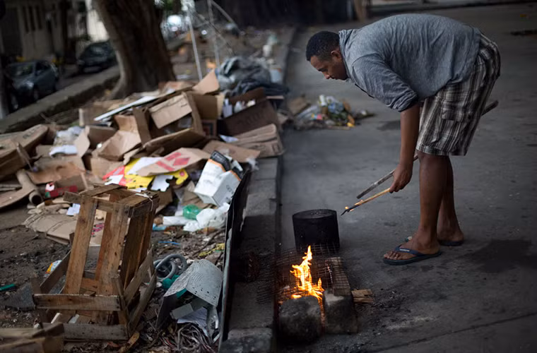 William, một người vô gia cư ở Brazil, nấu ăn trong công viên. Ảnh: AJ.