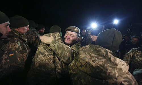 Tổng thống Ukraine Petro Poroshenko chào đón các binh sĩ Ukraine vừa được trao trả ở vùng Donetsk ngày 27/12. Ảnh: Reuters.