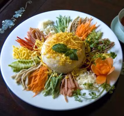 Trong quán chỉ sử dụng một chiếc đèn dầu cháy leo lắt, lại chỉ bán duy nhất món cơm bình dân trộn lẫn với thịt nạc, rau củ quả, ăn kèm nước chấm đủ ngũ sắc (trắng, xanh, vàng, đỏ, đen) nên khách hàng vui miệng mà gọi tên món cơm quán ấy là cơm âm phủ. Ảnh: Nét Huế.