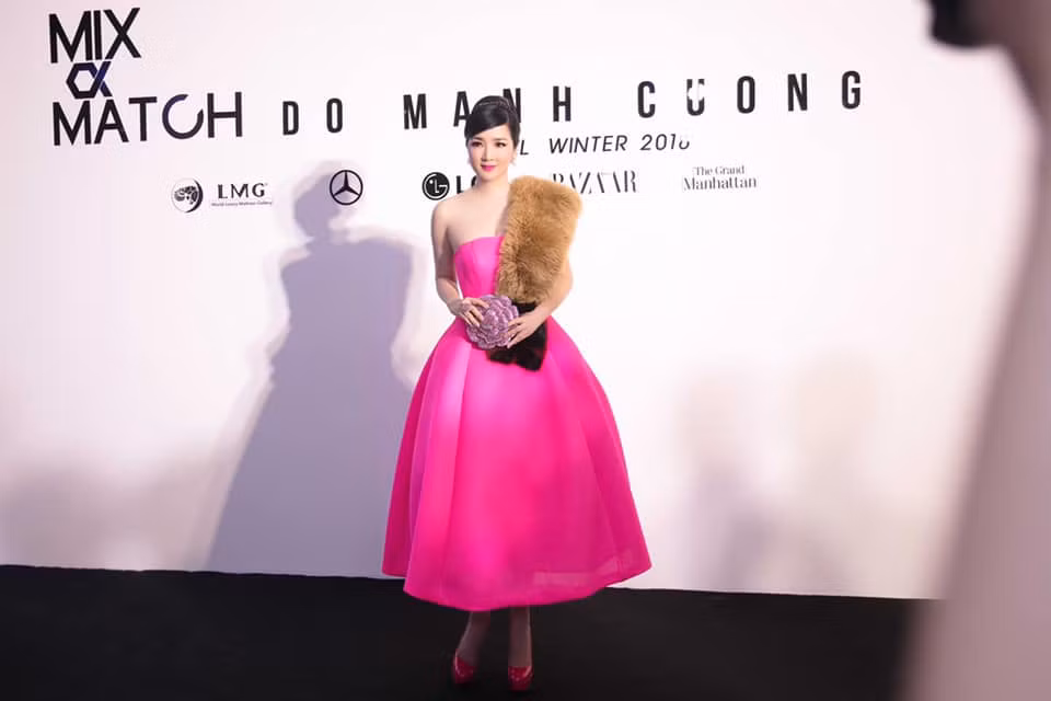 Giáng My mặc váy hồng cúp ngực xinh xắn với điểm nhấn là chiếc khăn choàng lông và clutch cánh hoa lấp lánh.