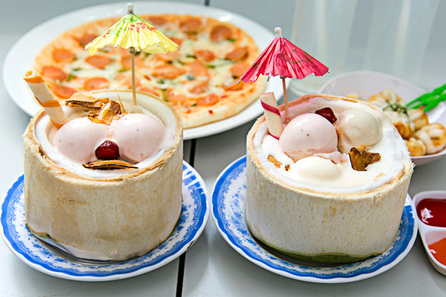 Kem trái dừa là một món ăn đường phố nổi tiếng nhất tại Thái Lan nên khi vừa xuất hiện tại Sài Gòn đã được nhiều bạn trẻ săn đón. Đơn giản chỉ là lớp kem lạnh được cuộn lại và gói ghém khéo léo trong chiếc vỏ dừa, nhưng nhờ vậy mà tạo nên nét mới lạ cho món ăn. Ảnh: Foody, Internet.