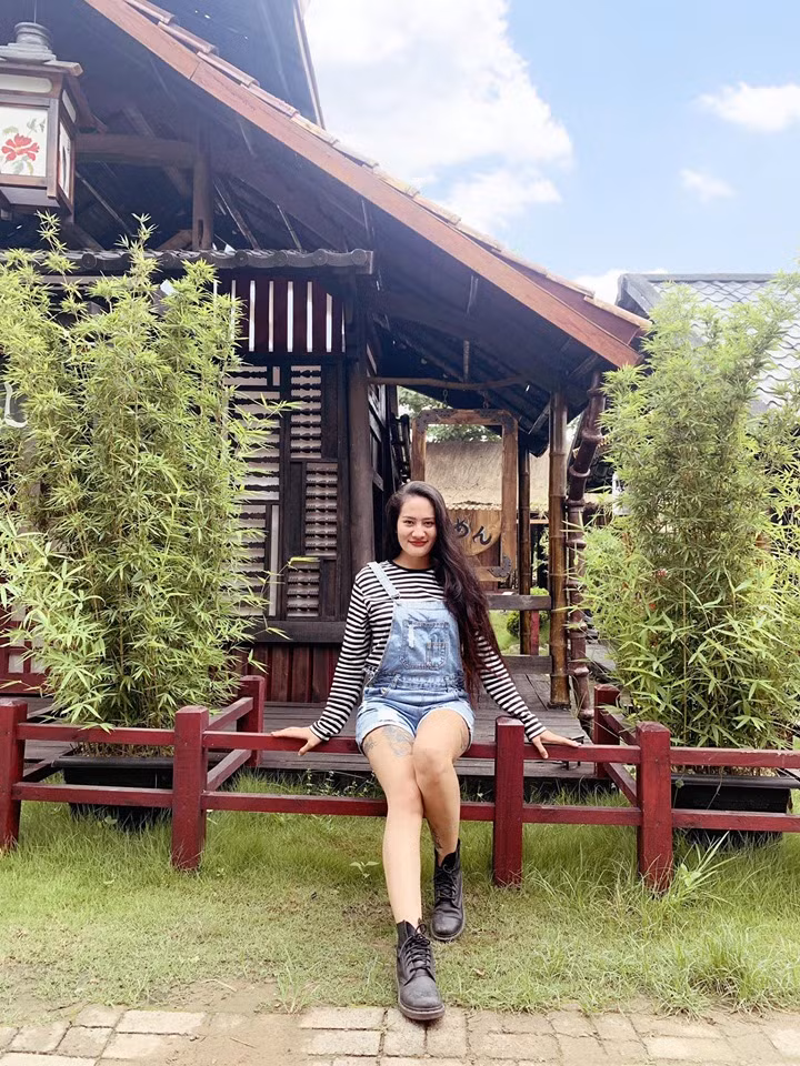 Khi đi chơi, cô chọn áo thun phối với quần yếm bò trẻ trung.