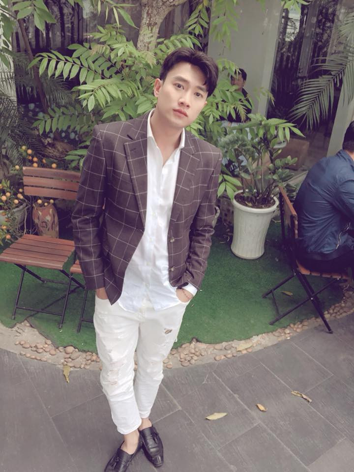 Anh có cách phối đồ rất phá cách khi diện vest với quần jean trắng rách gối.