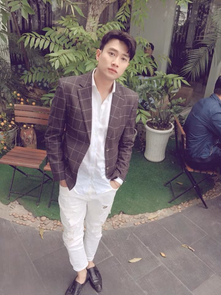 Anh có cách phối đồ rất phá cách khi diện vest với quần jean trắng rách gối.