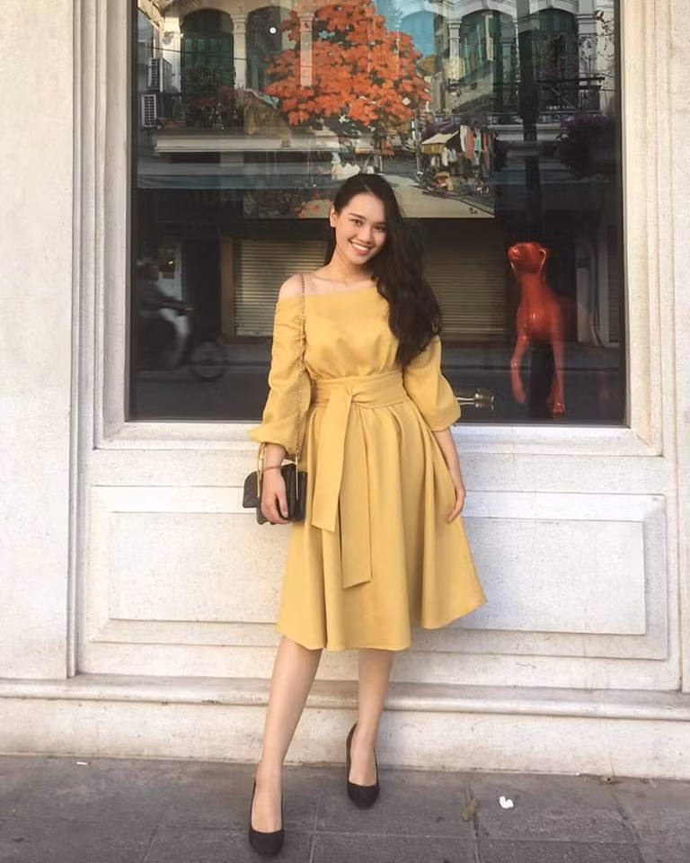 Cô diện chiếc váy vàng trễ vai có vạt thắt eo nhấn nhá vô cùng thời thượng.