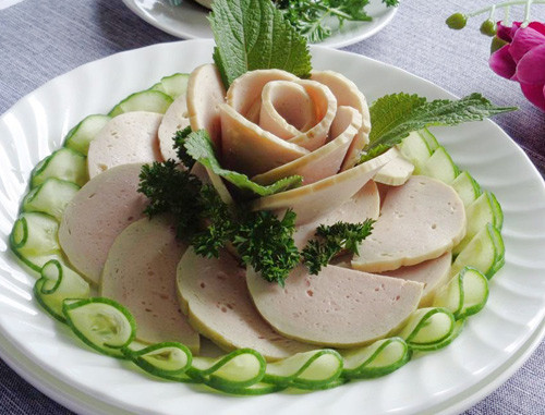 Cắt giò hình bán nguyệt, lát mỏng. Cuốn lại tạo thành bông hoa ở giữa (có thể dùng ly nhỏ để làm trụ). Bày thêm dưa leo và vài lát giò xung quanh đĩa bên dưới là xong.