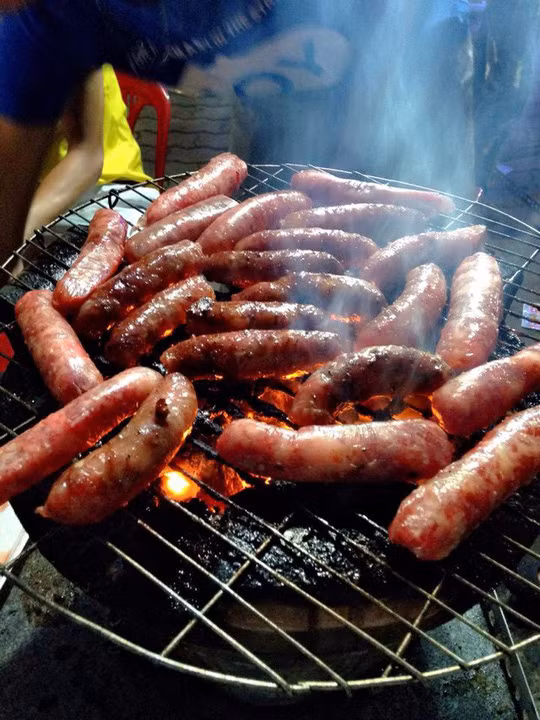 Nhờ ướp tẩm gia vị theo công thức độc đáo mà món ăn mang đến hương vị lạ lẫm khiến người ta nhớ mãi. Những chiếc lạp xưởng căng tròn, đầy đặn nướng mọi trên than hồng vừa beo béo vừa ngọt thơm nâng niu từng cung bậc vị giác.