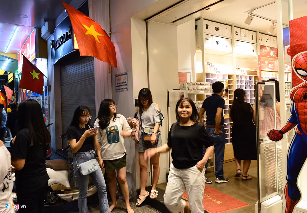 Các hàng quán hai bên con phố cũng đông đúc khách ghé mua.