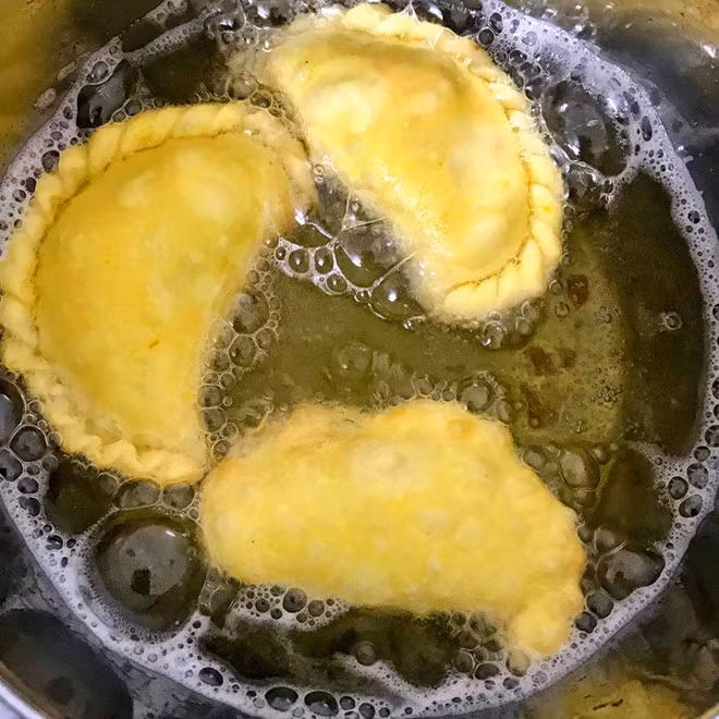 Chiên bánh gối: Đặt nồi dầu lên bếp đun cho dầu nóng thì thả từng chiếc bánh vào chiên ở lửa vừa, bánh có màu vàng nhạt thì vớt ra và đợi 5 phút sau cho vào chiên lần 2. Như vậy bánh sẽ chín vàng và giòn ngon hơn.